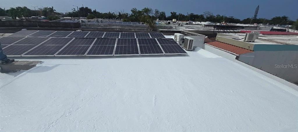A flat white roof features a large array of solar panels and an air conditioning unit — 210 CALLE FIRMAMENTO, CAROLINA, PR