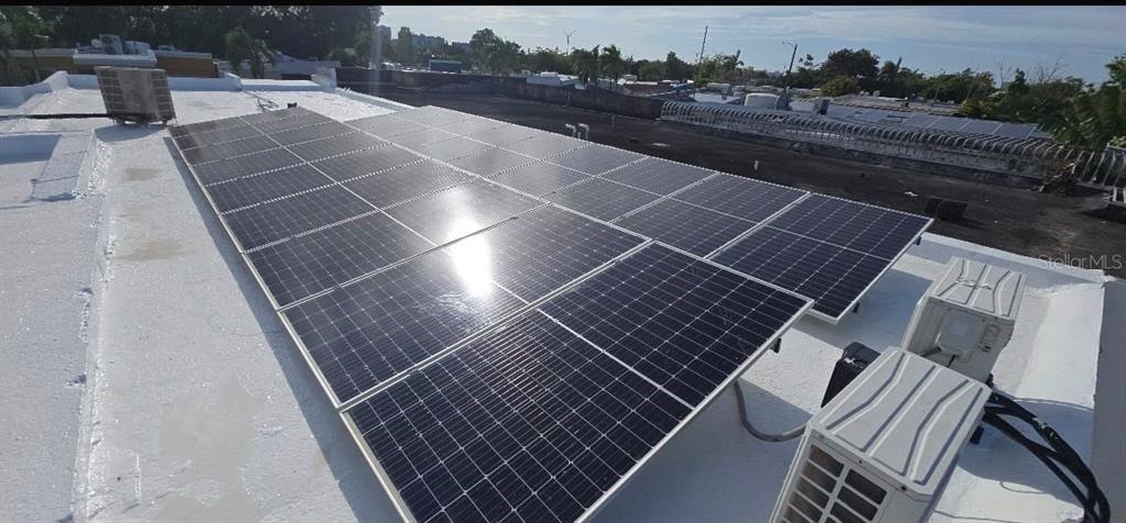 A flat roof features a large array of solar panels and two outdoor HVAC units — 210 CALLE FIRMAMENTO, CAROLINA, PR