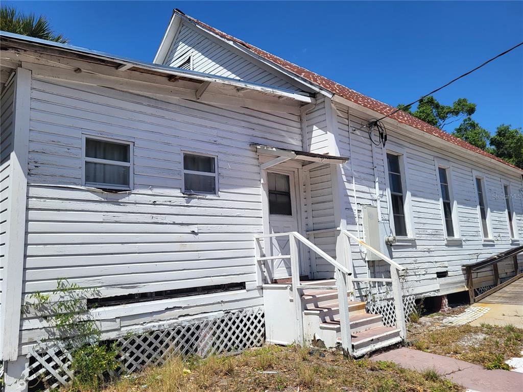 A white wood-sided house with a small porch, stairs, and lattice skirting — 2902 N ALBANY AVENUE, TAMPA, FL