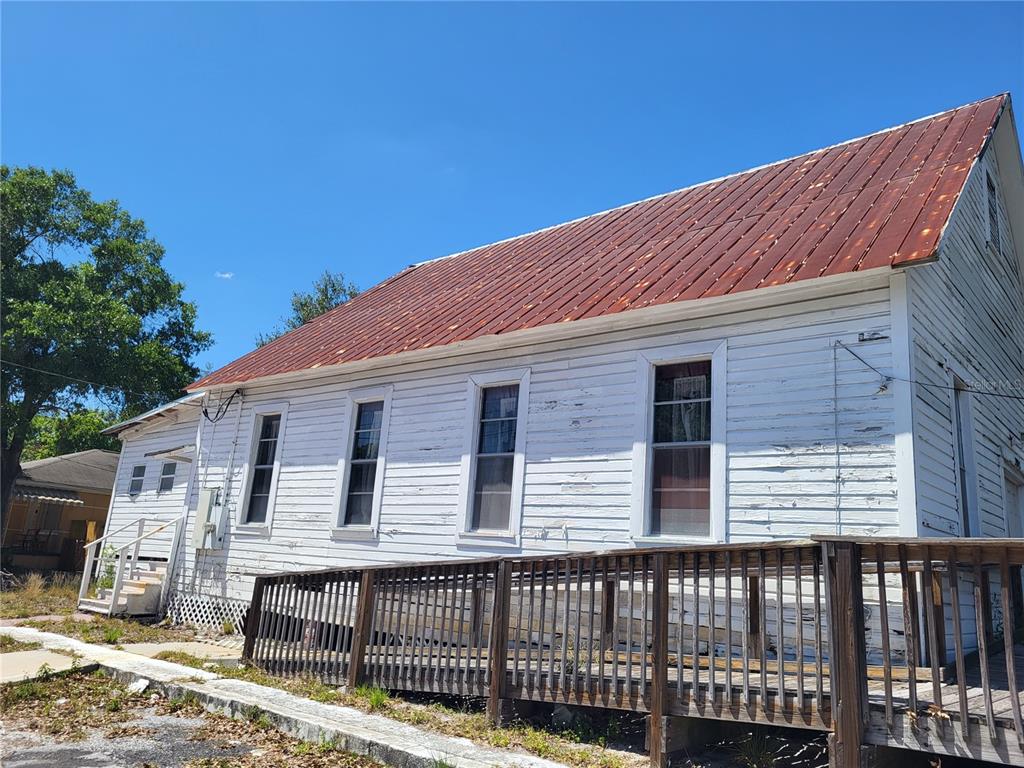 A weathered white wooden building with a rusty metal roof and a wooden wheelchair ramp — 2902 N ALBANY AVENUE, TAMPA, FL