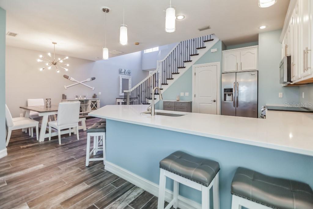 A kitchen with a white island, light blue cabinets, and an adjacent dining area — 1340 RIBOLLA DRIVE, PALM HARBOR, FL