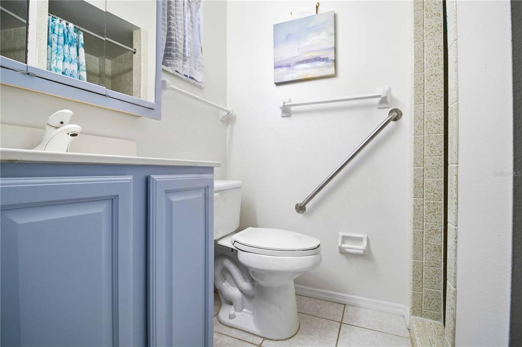 A bathroom features a light blue vanity, a white toilet, and a wall-mounted grab bar — 2814 SWIFTON DRIVE UNIT 108, SARASOTA, FL