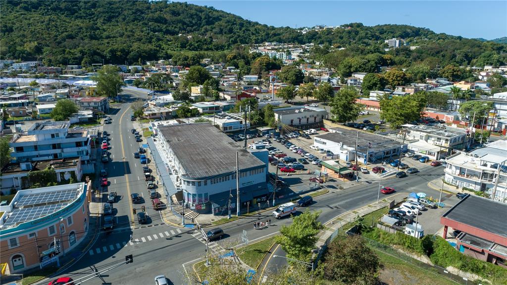 An aerial view shows a commercial building with a parking lot in a town setting — Ave Castro Perez, SAN GERMAN, SAN GERMAN, PR