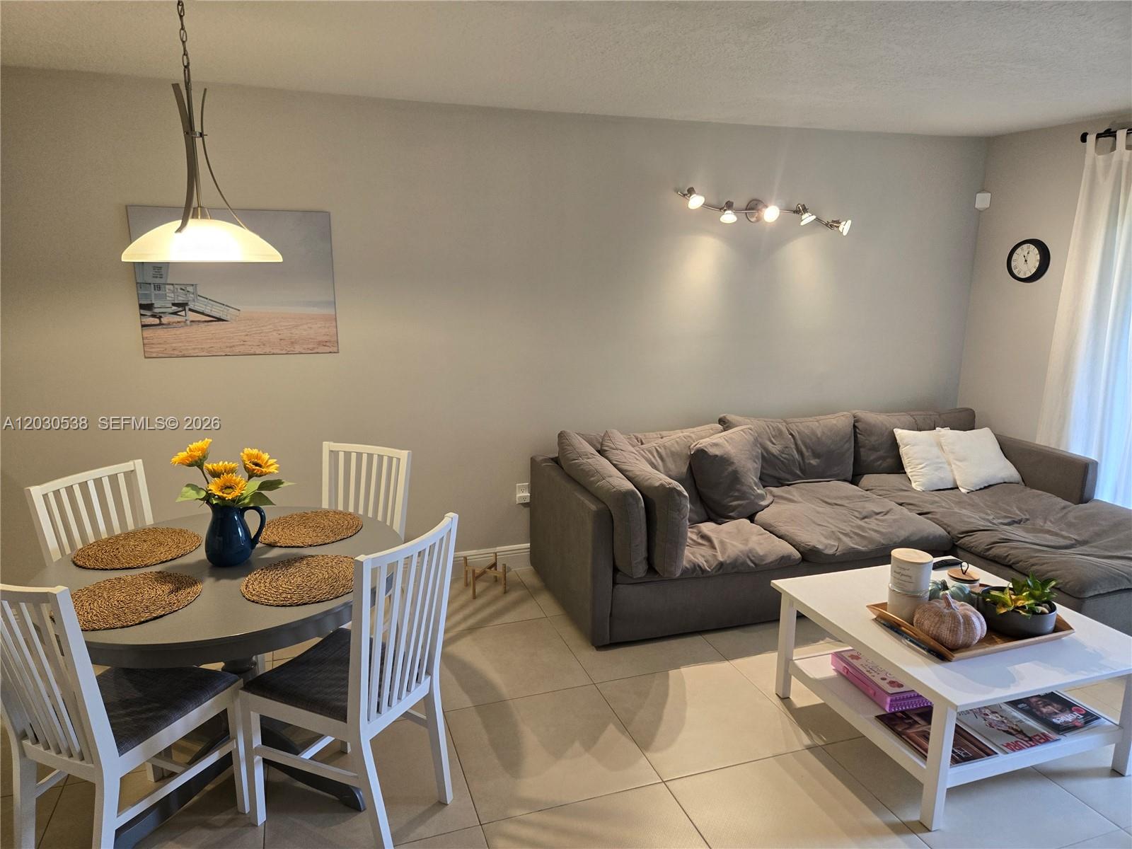 A dining area with a round table and a living room with a gray sectional sofa — 11213 SW 88 ST # 110B, Miami FL 33176, MIAMI, FL