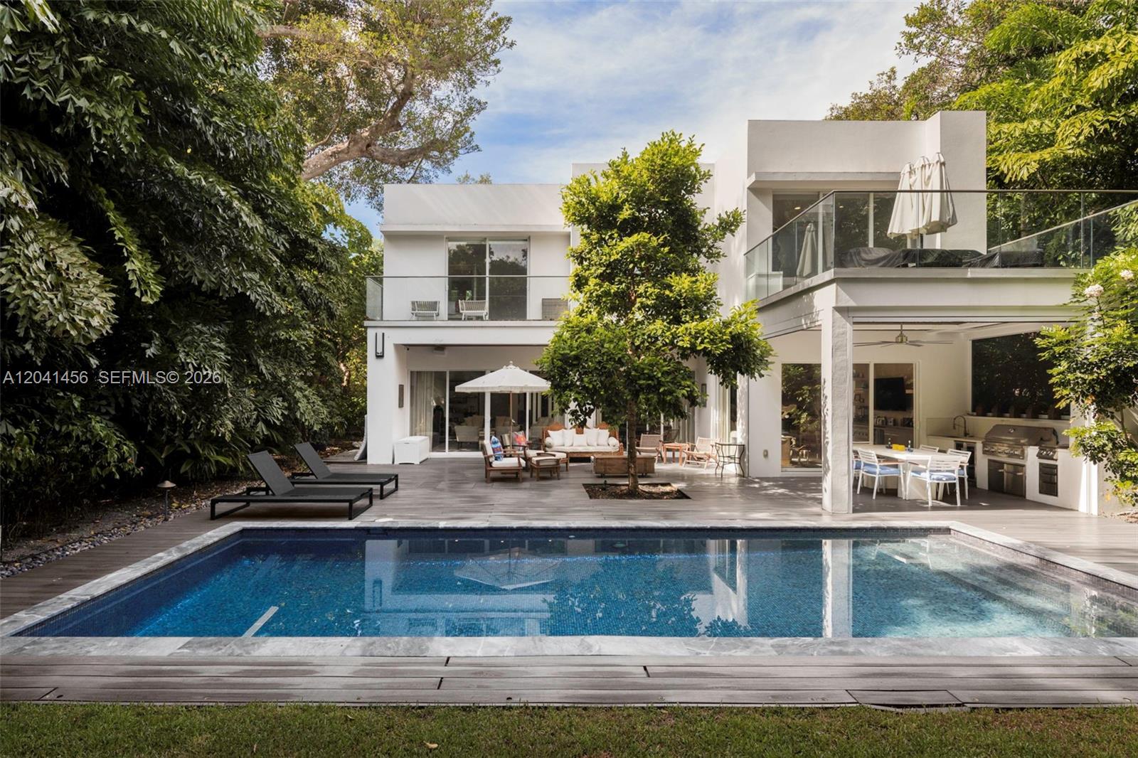 A modern two-story white house features a swimming pool, patio, and outdoor kitchen area — 3901 Kumquat Ave, Miami FL 33133, MIAMI, FL