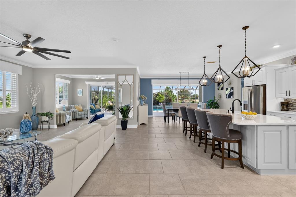 An open-concept living area features a kitchen with a large island, dining space, and patio — 9133 SW 82ND LANE, OCALA, FL