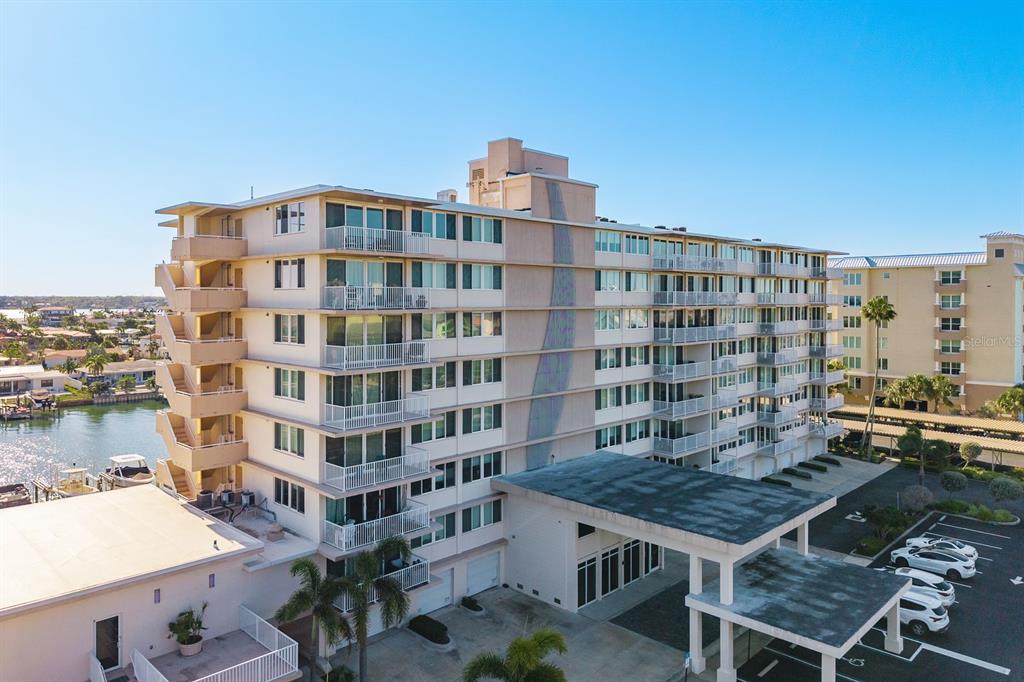 An aerial view of a multi-story apartment building with balconies and a covered entrance — 223 ISLAND WAY UNIT 2D, CLEARWATER BEACH, FL