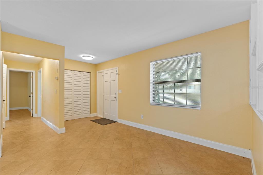 An entryway with yellow walls, tile flooring, a white front door, and a closet — 7369 TARRYTOWN DRIVE, SPRING HILL, FL