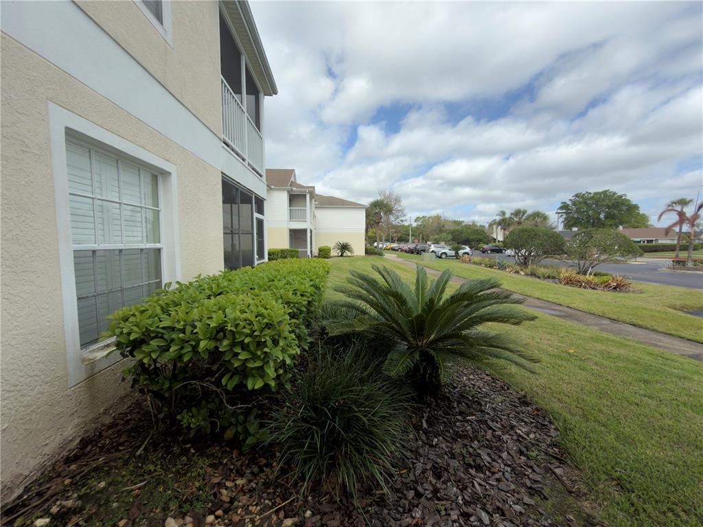 A view of the exterior of a multi-story apartment building with landscaping and a parking lot — 3930 SOUTHPOINTE DRIVE UNIT 205, ORLANDO, FL