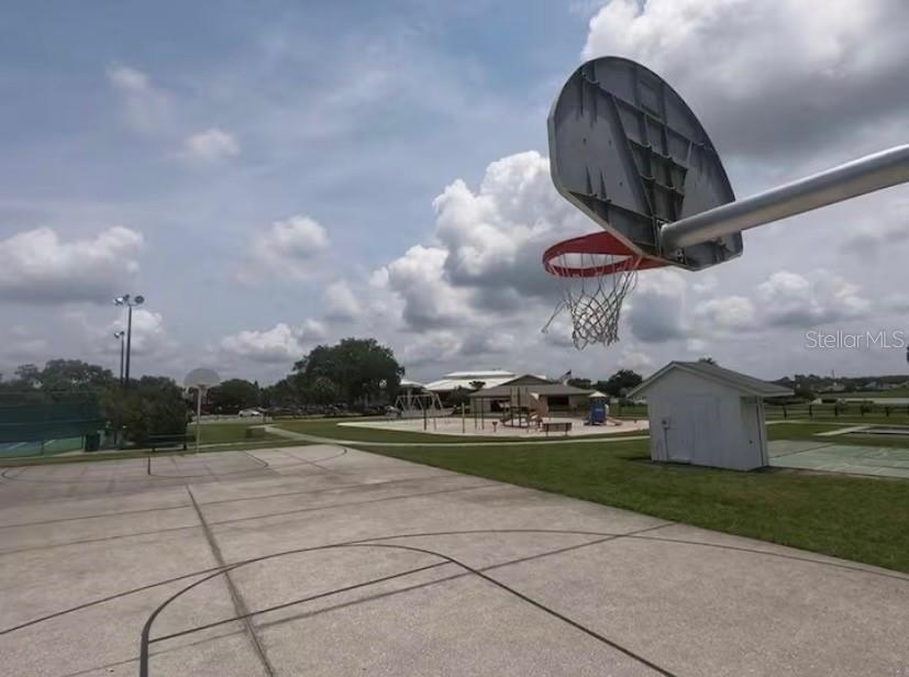 An outdoor basketball court with a hoop, a small shed, and a playground in the background — 3930 SOUTHPOINTE DRIVE UNIT 205, ORLANDO, FL