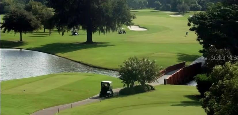 An aerial view of a golf course featuring a pond, a bridge, and a golf cart — 3930 SOUTHPOINTE DRIVE UNIT 205, ORLANDO, FL