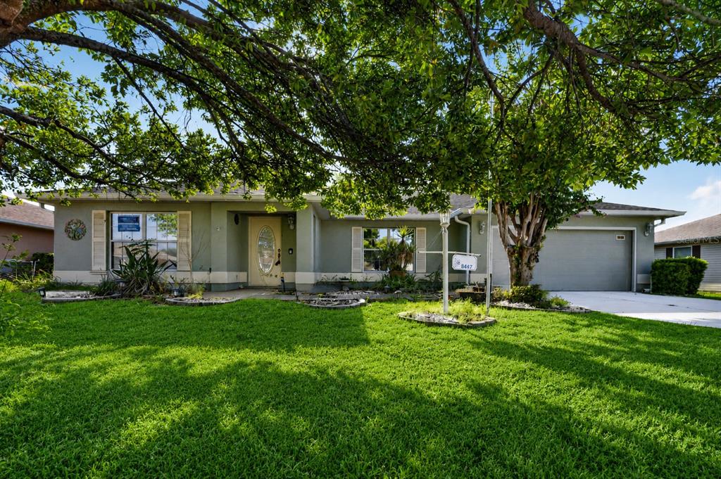 A single-story house with a green exterior, a two-car garage, and a large front tree — 8447 SW 60TH COURT, OCALA, FL