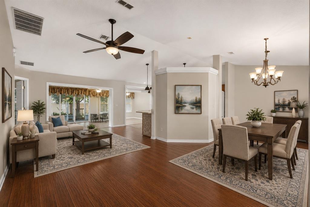 An open-concept living and dining area with hardwood floors, neutral walls, and a ceiling fan — 8447 SW 60TH COURT, OCALA, FL