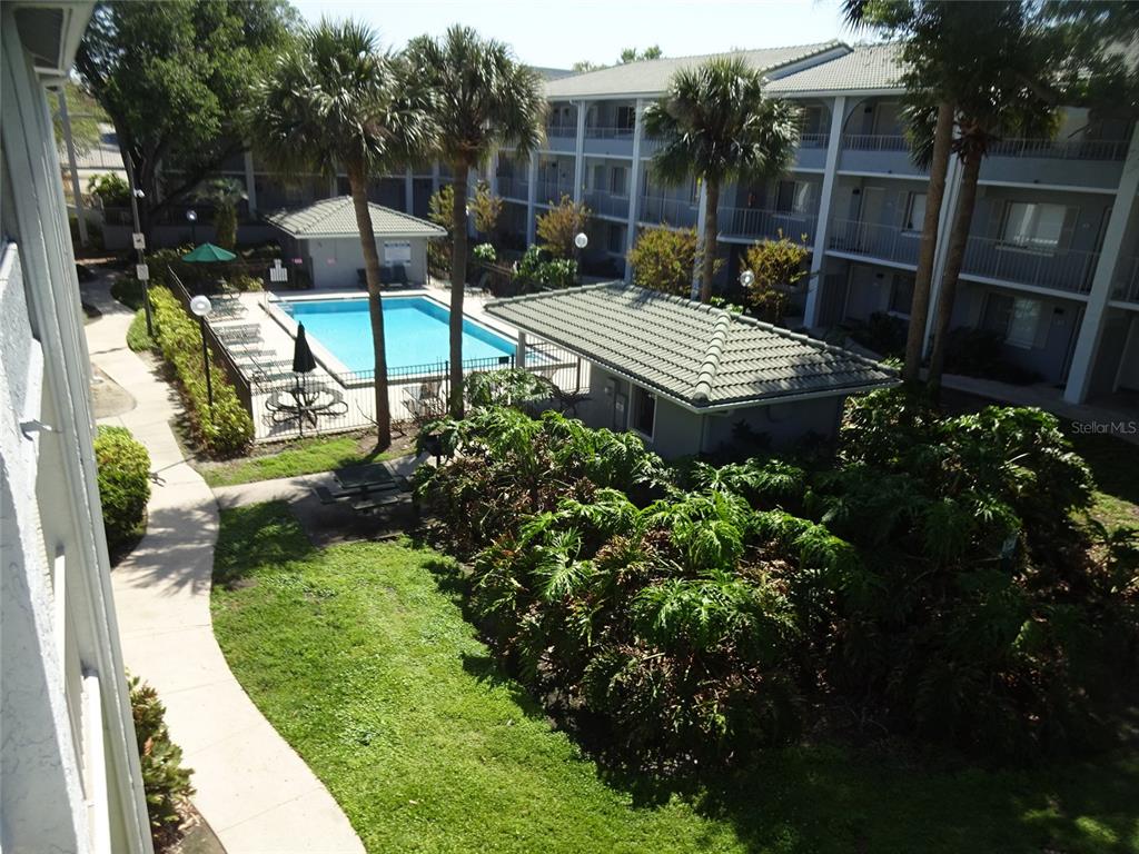 An elevated view of an apartment complex courtyard featuring a swimming pool and covered patio — 123 BLUE POINT WAY UNIT 100, ALTAMONTE SPRINGS, FL
