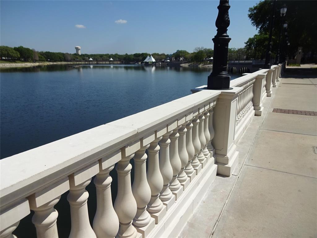 A stone balustrade railing overlooks a calm lake on a sunny day — 123 BLUE POINT WAY UNIT 100, ALTAMONTE SPRINGS, FL