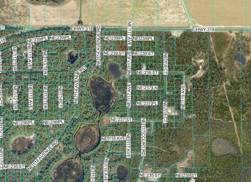 This is an aerial map showing a residential area with property lines and street names — NE 239TH ST, FORT MC COY, FL