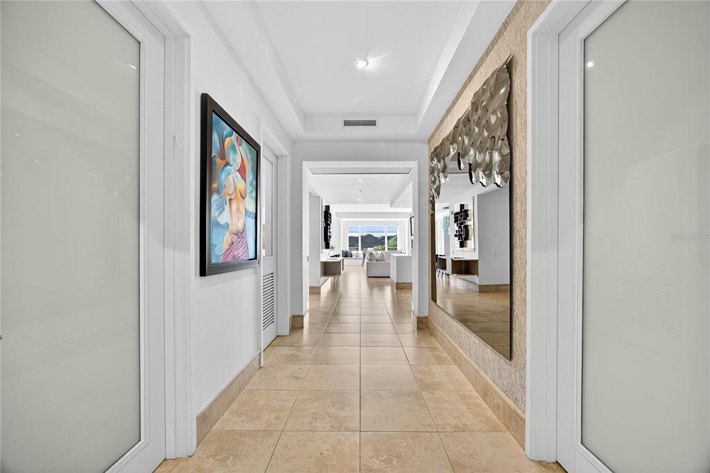 A bright hallway with tile flooring, a large wall mirror, and a framed painting — . COND PLANTATION VILLAGE STREET UNIT 3-303, DORADO, PR