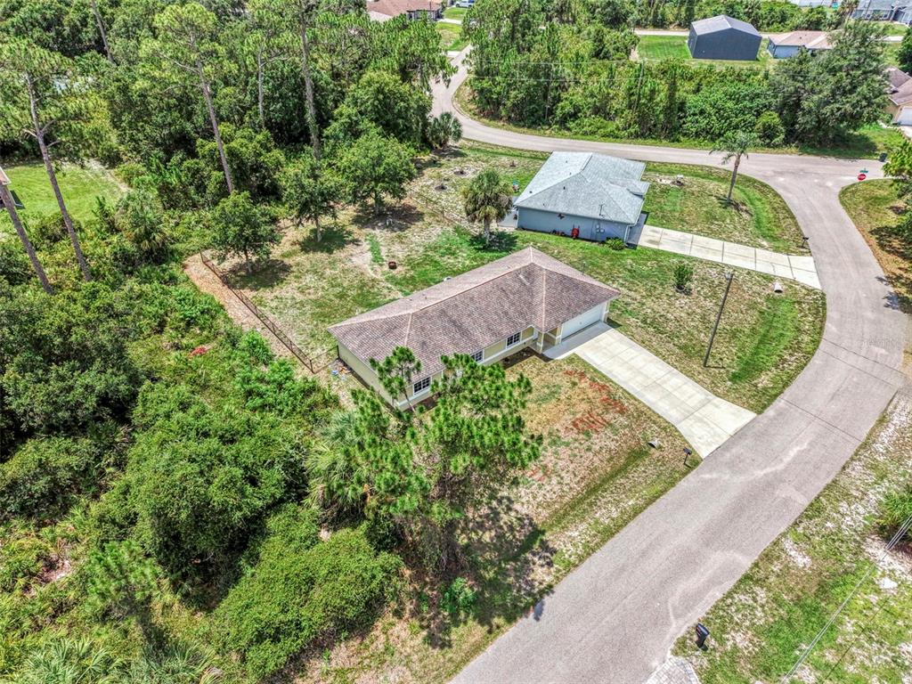 An aerial view shows a single-story house with a brown roof and concrete driveway — 4845 HADER ROAD, NORTH PORT, FL