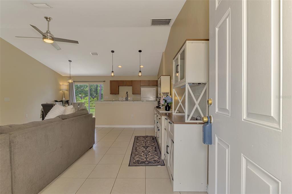 A view from an entryway into an open-concept living room and kitchen with tile flooring — 4845 HADER ROAD, NORTH PORT, FL
