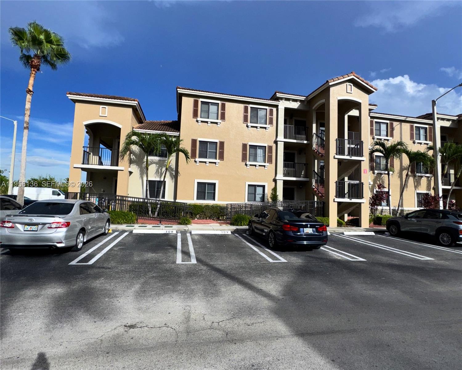 A three-story apartment building with tan stucco walls and a parking lot in front — 22441 SW 88th Pl # 5, Cutler Bay FL 33190, CUTLER BAY, FL