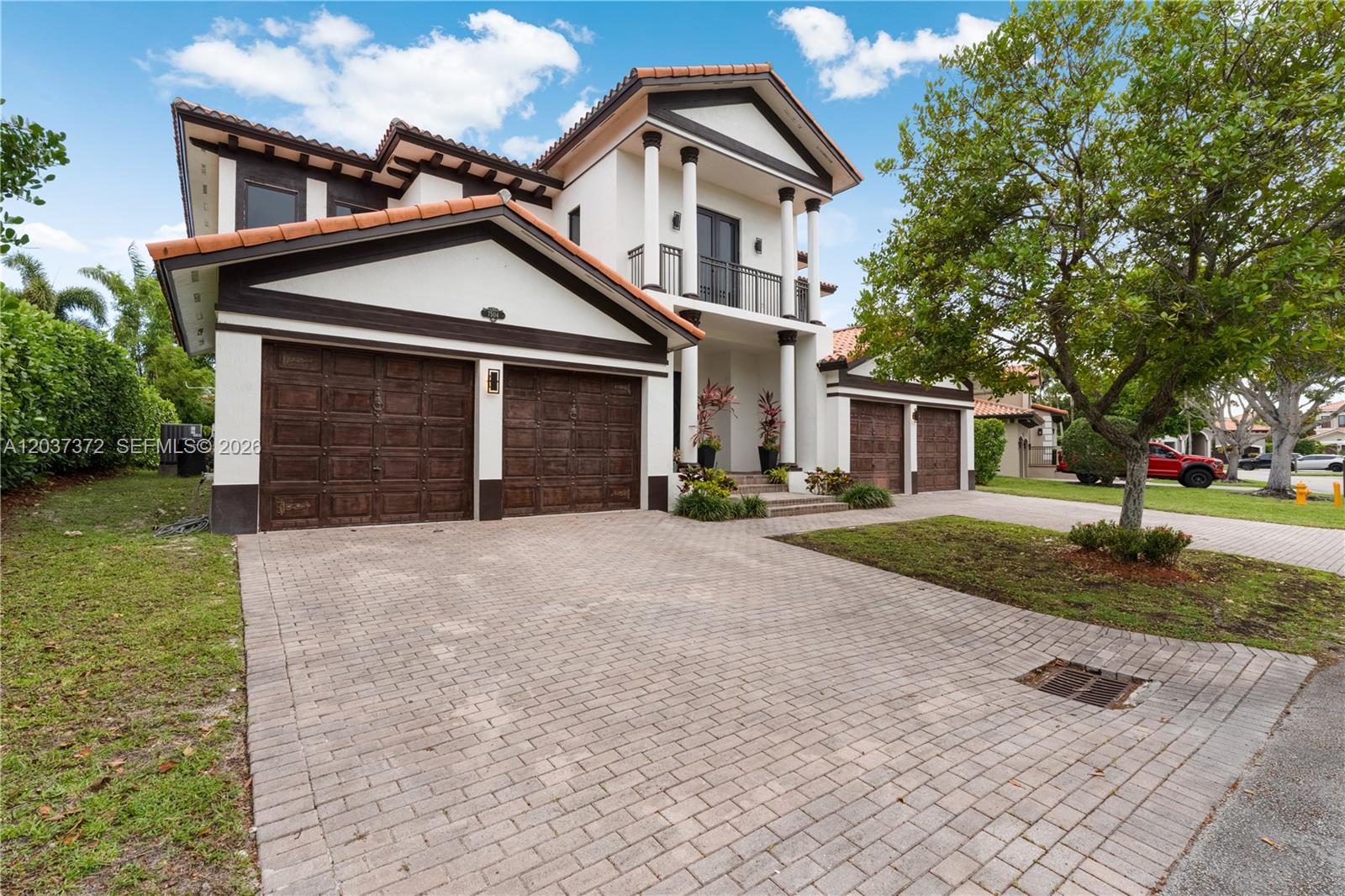 A two-story house features a paved driveway, a three-car garage, and a tiled roof — 7504 SW 188th Ter, Cutler Bay FL 33157, CUTLER BAY, FL