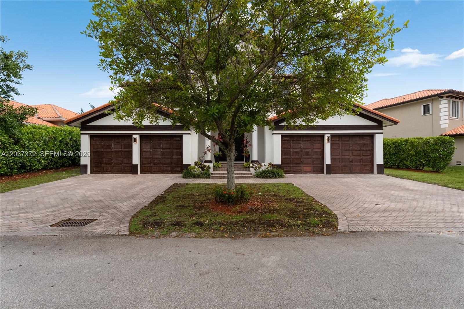 A two-story house features a four-car garage, a paved driveway, and a central tree — 7504 SW 188th Ter, Cutler Bay FL 33157, CUTLER BAY, FL