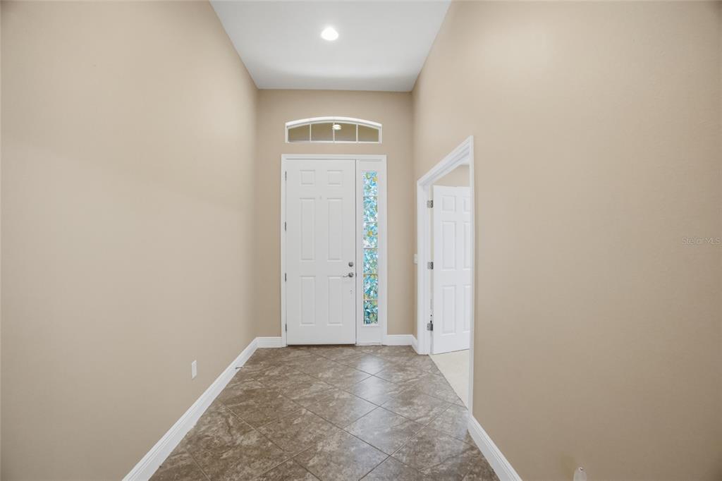 An entryway features tan walls, tile flooring, a white front door, and a transom window — 11504 HARLAN EDDY COURT, RIVERVIEW, FL