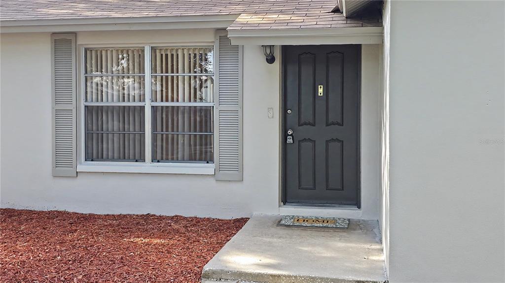 A kitchen features white cabinets, granite countertops, stainless steel appliances, and light-colored tile flooring — 7419 IVORY TERRACE, NEW PORT RICHEY, FL