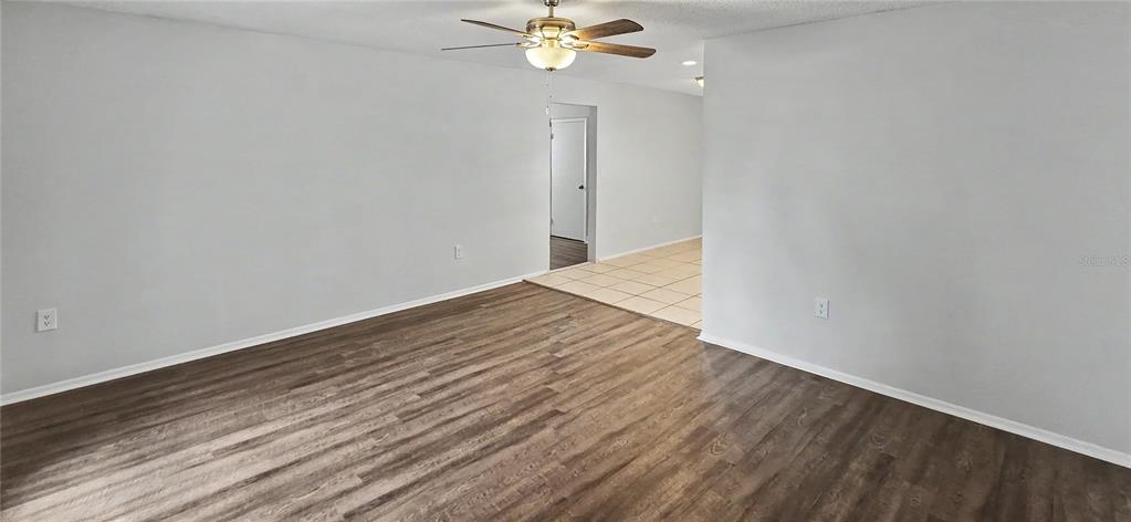 A kitchen with white cabinets, granite countertops, stainless steel appliances, and light-colored tile flooring — 7419 IVORY TERRACE, NEW PORT RICHEY, FL