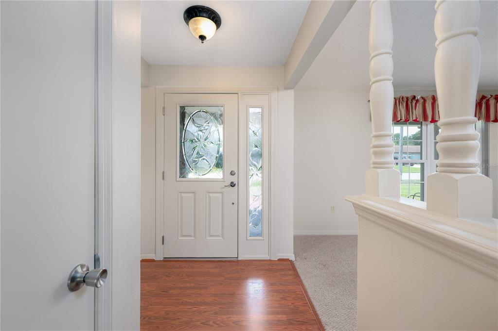 An entryway features a wood floor, a white front door with glass, and a staircase — 3219 HIDALGO DRIVE, ORLANDO, FL