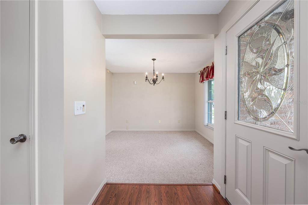 A view from an entryway into a carpeted dining room with a chandelier — 3219 HIDALGO DRIVE, ORLANDO, FL