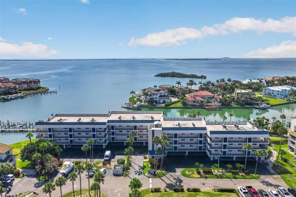A boat is lifted on a mechanical dock system over calm water under a blue sky — 363 PINELLAS BAYWAY S UNIT 42, ST PETERSBURG, FL