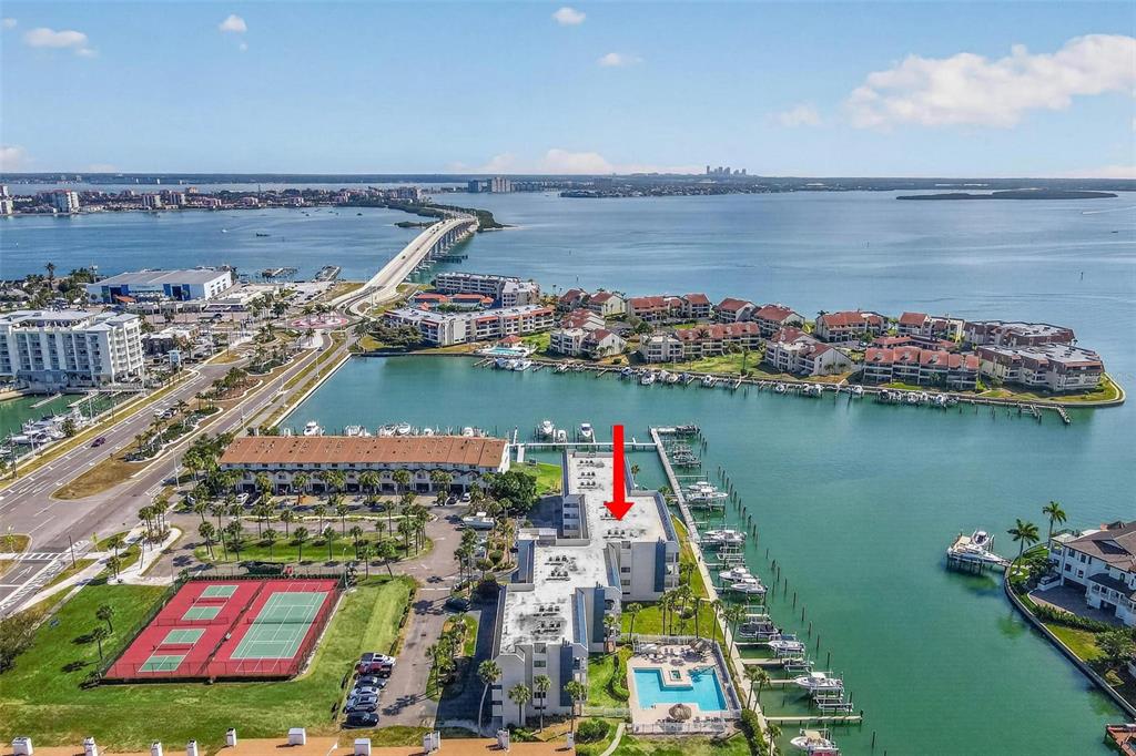 The exterior of a multi-story apartment building features a prominent Anchor Cove sign and landscaping — 363 PINELLAS BAYWAY S UNIT 42, ST PETERSBURG, FL