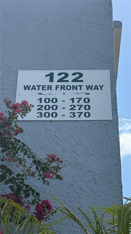 A sign on a textured blue wall displays the address and unit number ranges — 122 WATER FRONT WAY UNIT 340, ALTAMONTE SPRINGS, FL