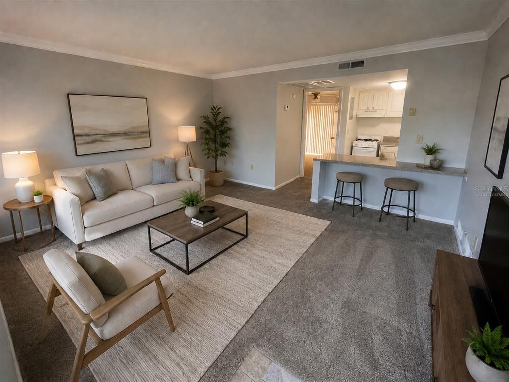 A living room with a sofa, coffee table, and breakfast bar leading to a kitchen — 122 WATER FRONT WAY UNIT 340, ALTAMONTE SPRINGS, FL