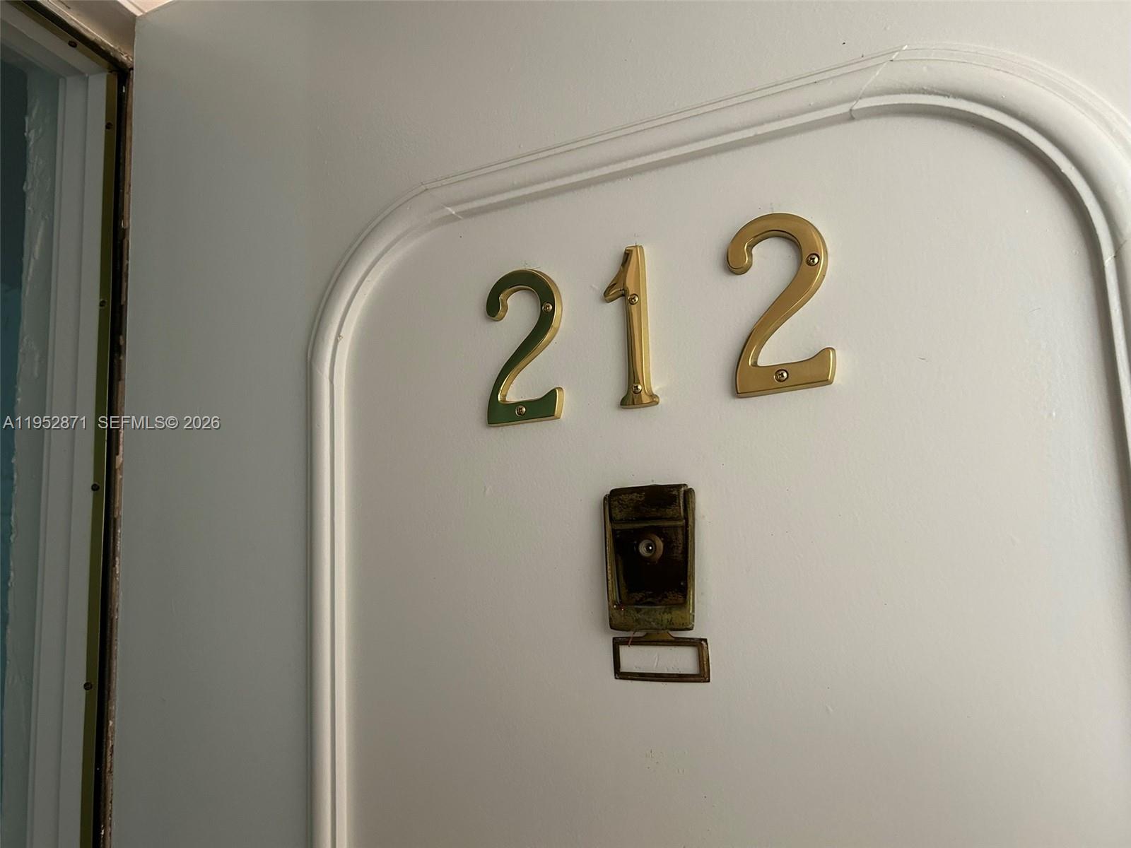 A white door features the brass house number 212 and a vintage doorbell mechanism — 5640 SW 3rd Pl # 212, Margate FL 33068, MARGATE, FL