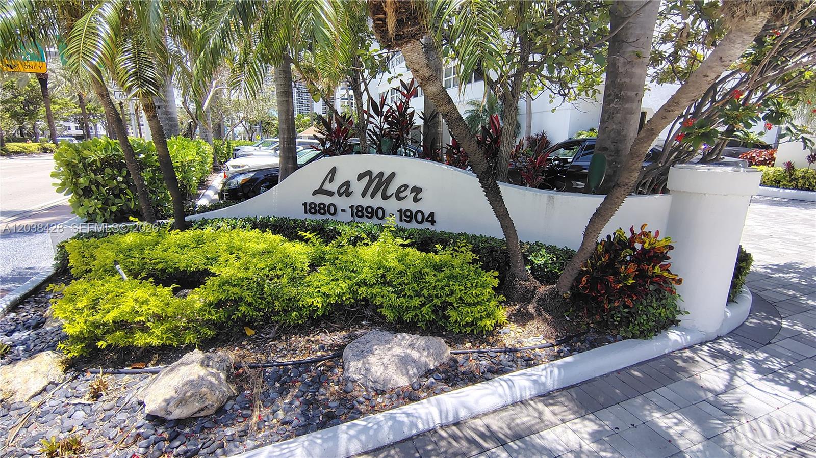A white curved monument sign for La Mer stands in a landscaped garden area — 1904 S Ocean Dr # 1807, Hallandale Beach FL 33009, HALLANDALE BEACH, FL