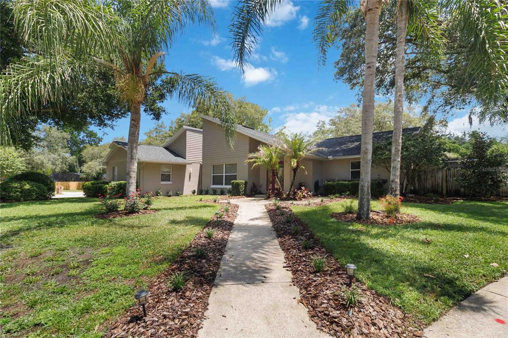 A single-story house with a tan exterior, palm trees, and a concrete walkway — 176 TIM TAM COURT, LAKE MARY, FL