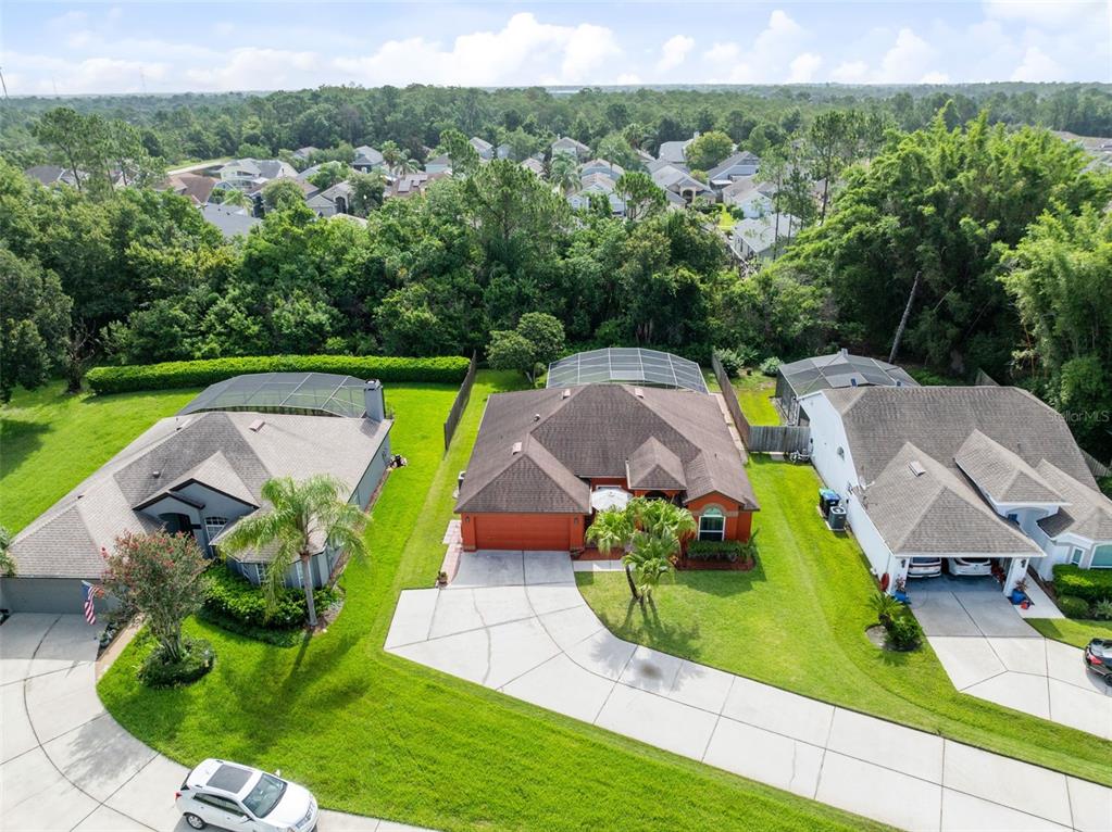 An aerial view shows three suburban houses with driveways and screened-in back patios — 949 ROSINIA COURT, ORLANDO, FL