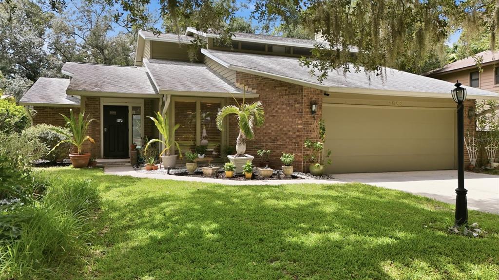 A single-story brick house with a two-car garage and a landscaped front yard — 1063 GREYSTONE LANE, SARASOTA, FL