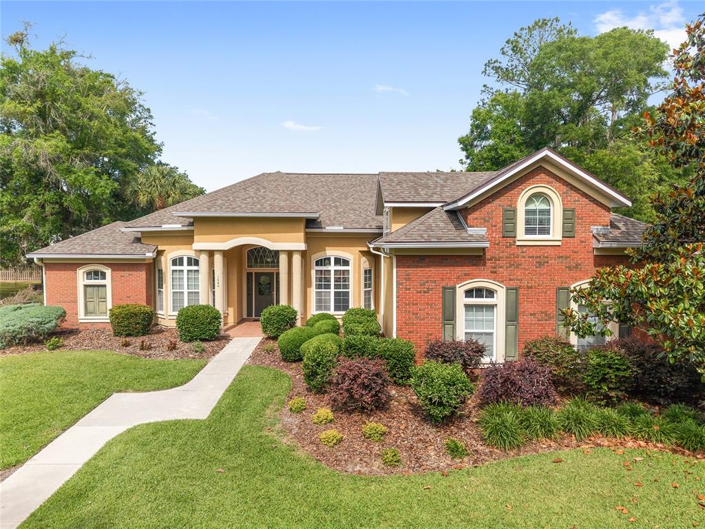 A one-story brick and stucco house with a front walkway and arched windows — 1446 SW 87TH STREET, GAINESVILLE, FL