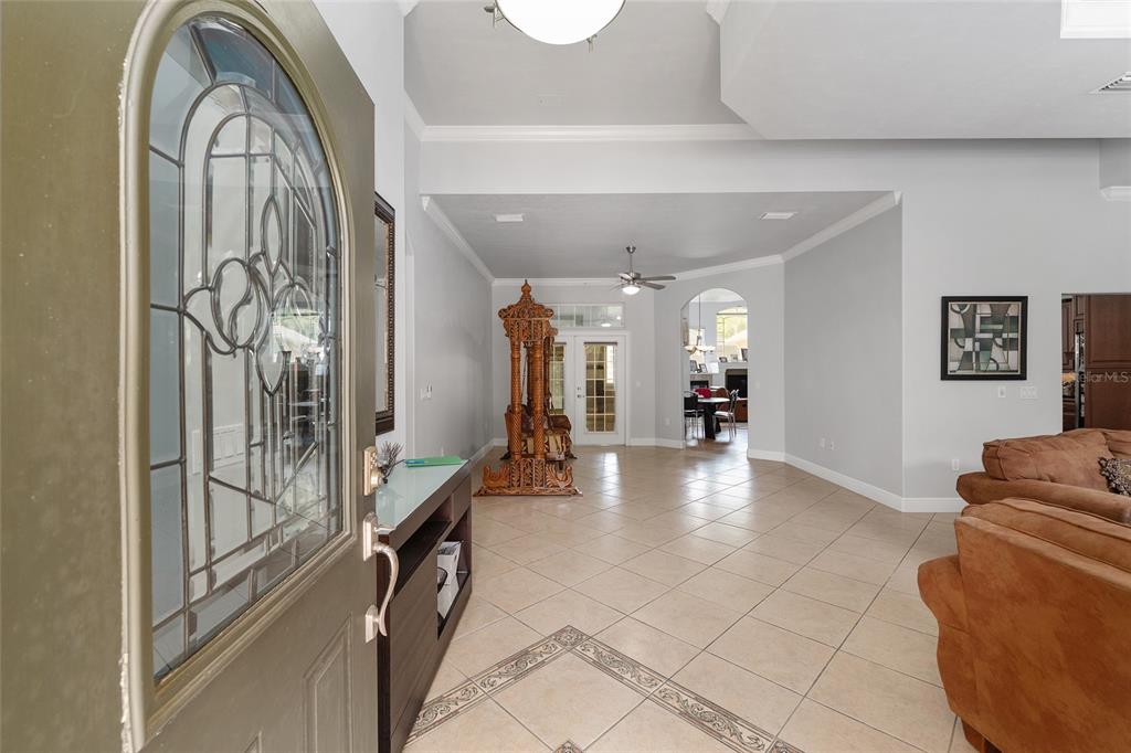 An entryway with tiled floors leads into a living area featuring a decorative wooden swing — 1446 SW 87TH STREET, GAINESVILLE, FL