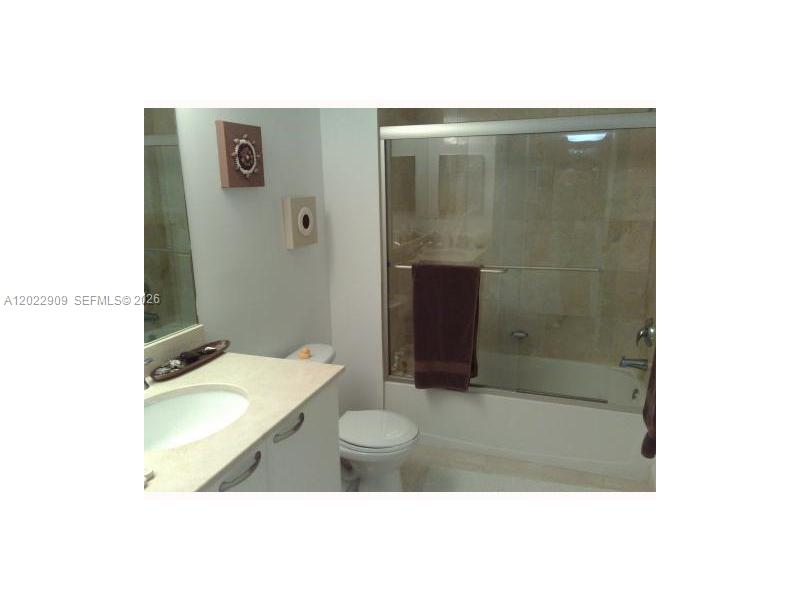 A bathroom features a vanity with a sink, a toilet, and a glass-enclosed shower — 2101 BRICKELL # 410, Miami FL 33131, MIAMI, FL