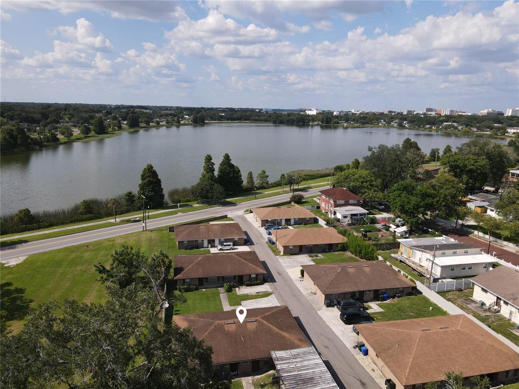 An aerial view shows a residential street with several single-story buildings near a large lake — 101 LAKE HUNTER DRIVE UNIT 12, LAKELAND, FL