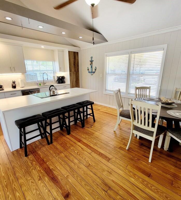 A kitchen and dining area with a white island, black stools, and hardwood floors — 1817 IVANHOE STREET UNIT A&B, SARASOTA, FL