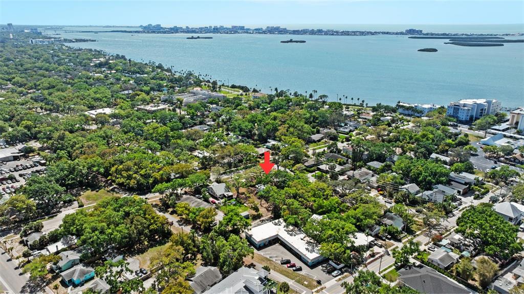 An aerial view shows a residential neighborhood with a red arrow pointing toward a lot — 308 PRESIDENT STREET, DUNEDIN, FL