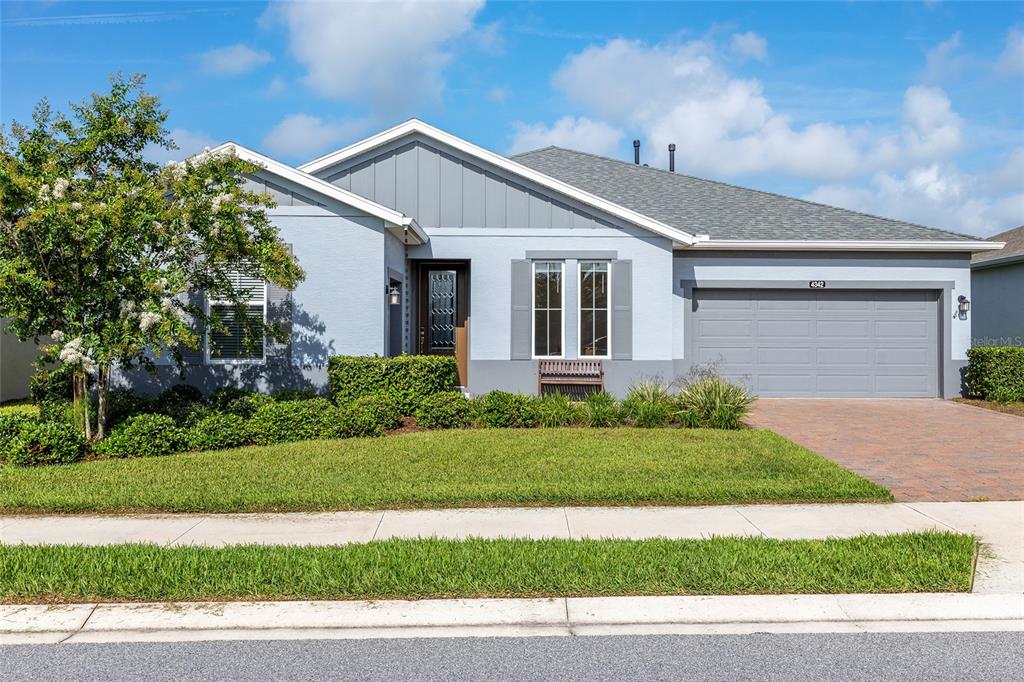 A single-story house with a gray exterior, a two-car garage, and a landscaped front yard — 4342 NW 55TH COURT, OCALA, FL