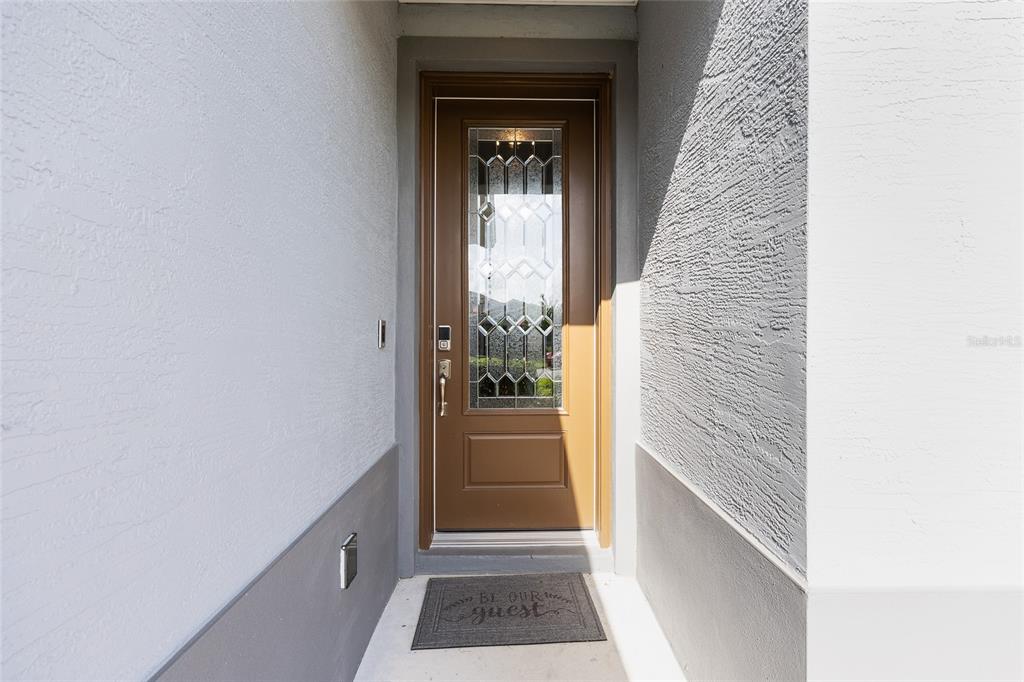 A brown front door with a decorative glass insert sits in a recessed entryway — 4342 NW 55TH COURT, OCALA, FL