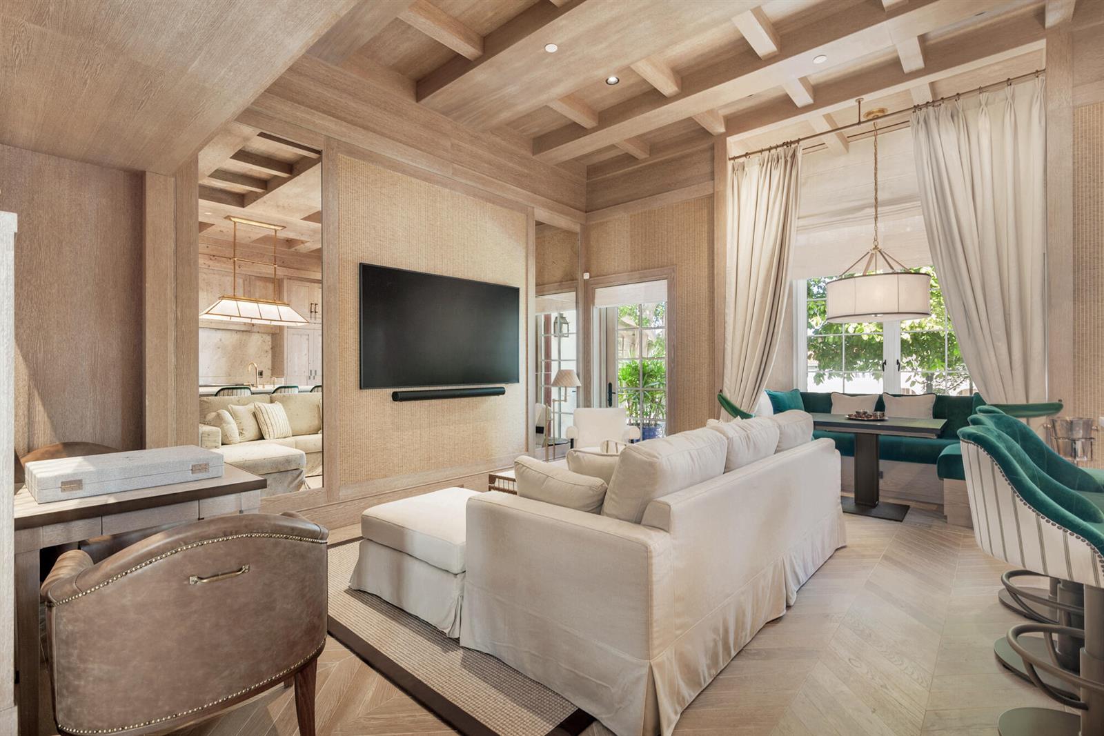 A living room with light wood paneling, a television, a sofa, and a dining nook — 236 Phipps Plaza # 201, Palm Beach FL 33480, PALM BEACH, FL