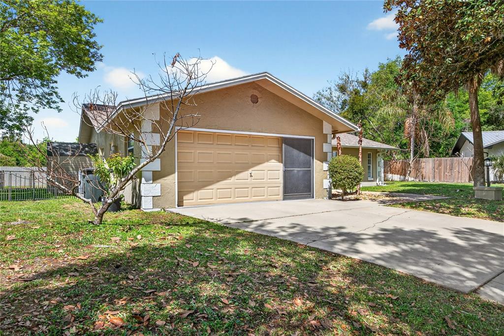 A tan house with a concrete driveway and a single-car garage door — 20 BLEAU COURT, PALM COAST, FL
